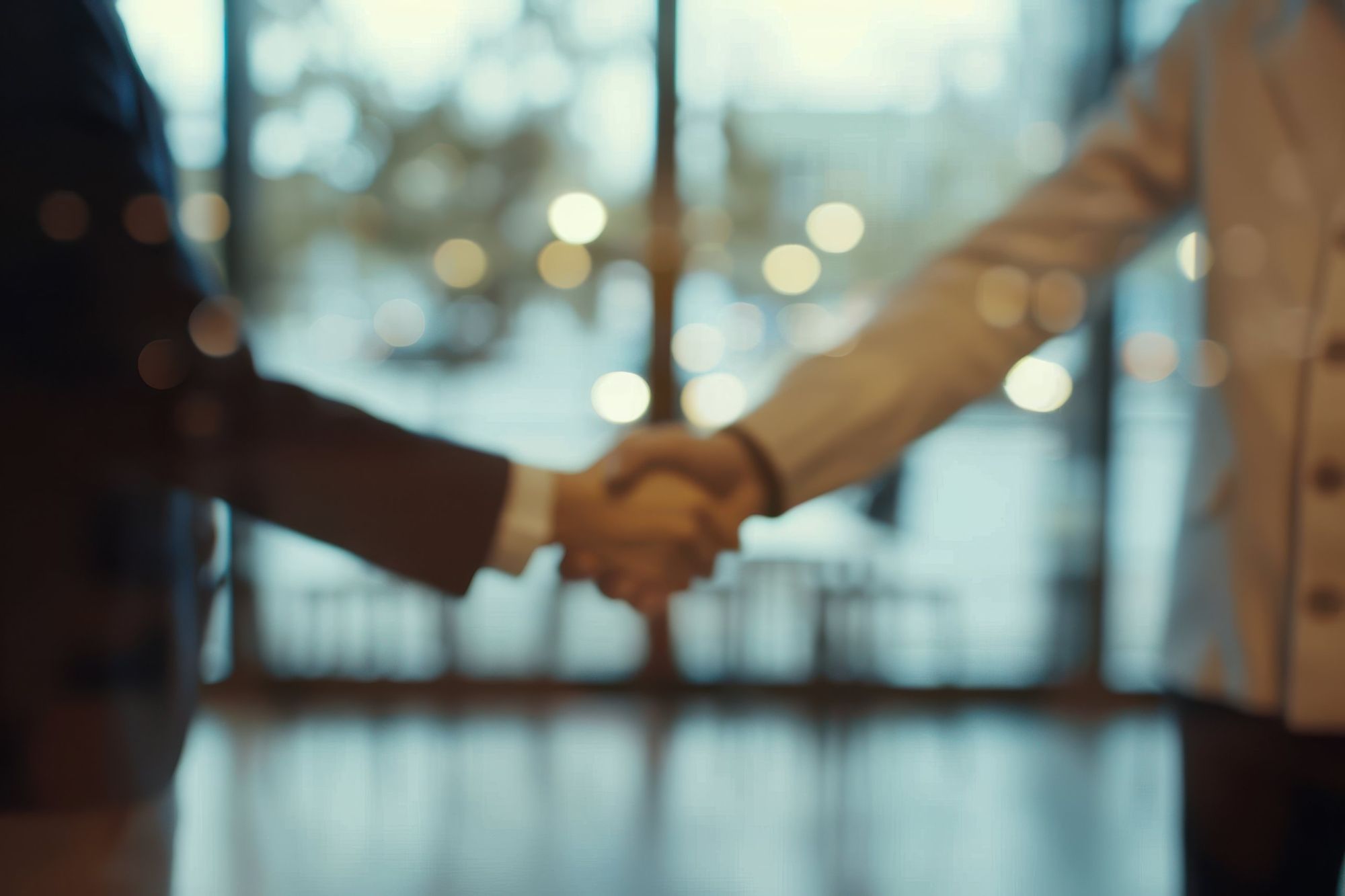 Aperto de mãos entre duas pessoas em um ambiente corporativo